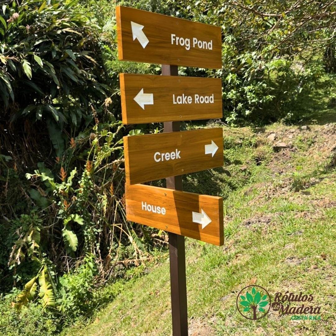 Rótulo direccional de madera para orientación en exteriores, fabricado con materiales duraderos y diseño personalizado.  Ideal para hoteles, senderos y proyectos turísticos.  Elaborado por Rótulos de Madera Costa Rica